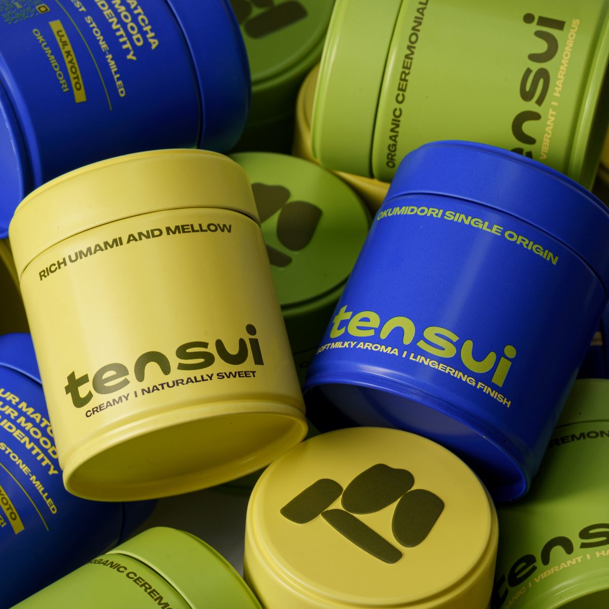 กระป๋องมัทฉะ Tensui หลากสีวางกองรวมกัน โชว์โลโก้ tensui